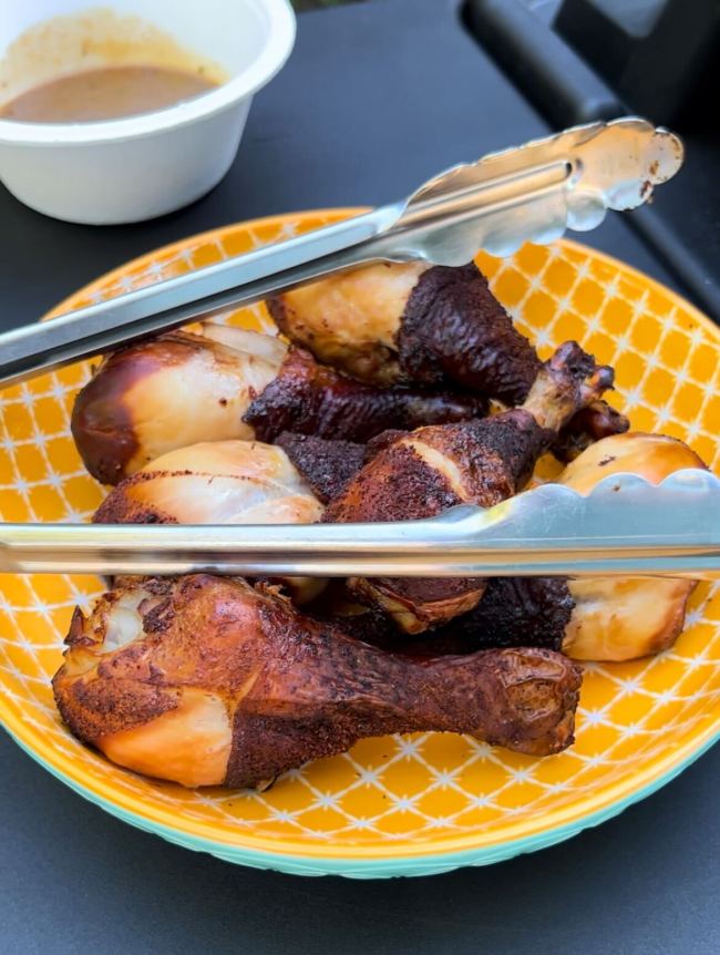 Smoked drumsticks in a bowl on the Ninja Woodfire™ Pro Connect XL Outdoor Grill & Smoker