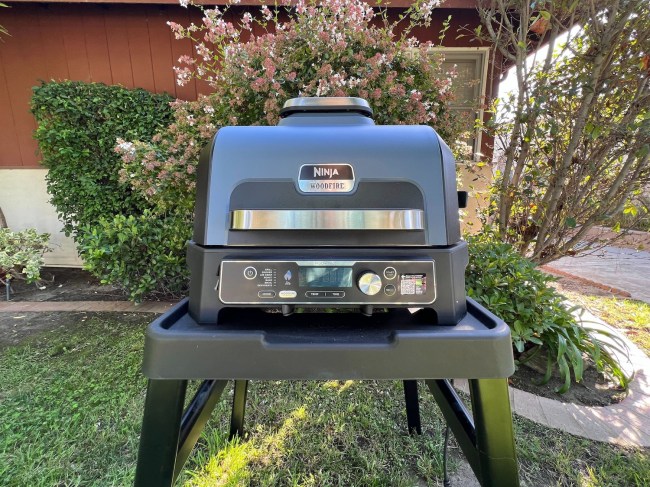 Ninja Woodfire™ Pro Connect XL Outdoor Grill & Smoker on a stand outside a home