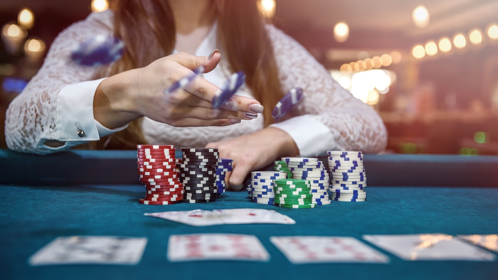 poker player moving chips on felt table