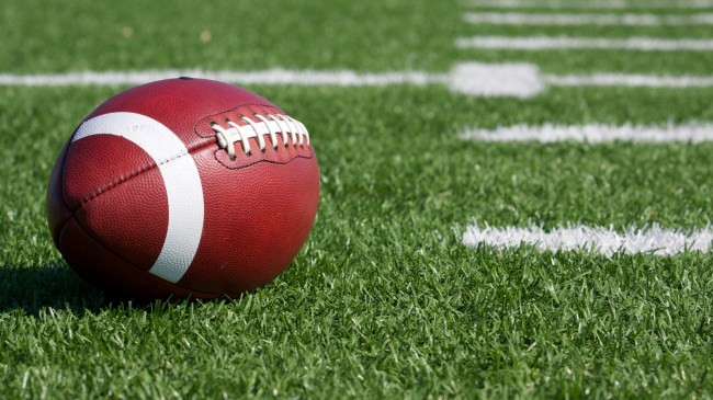 A football rests on a college football playing field.