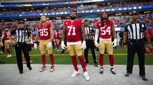 Trent Williams stands alongside 49ers teammates before a game.