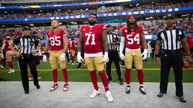 Trent Williams stands alongside 49ers teammates before a game.