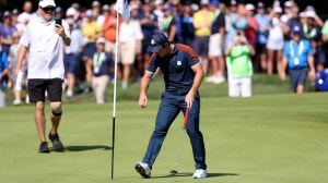 Viktor Hovland retrieves ball after hole-in-one at par-4 5th hole during Ryder Cup in Rome