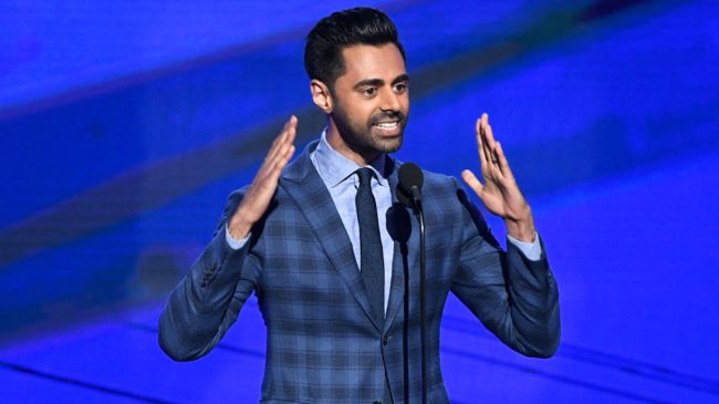 Hasan Minhaj on stage in a blue suit