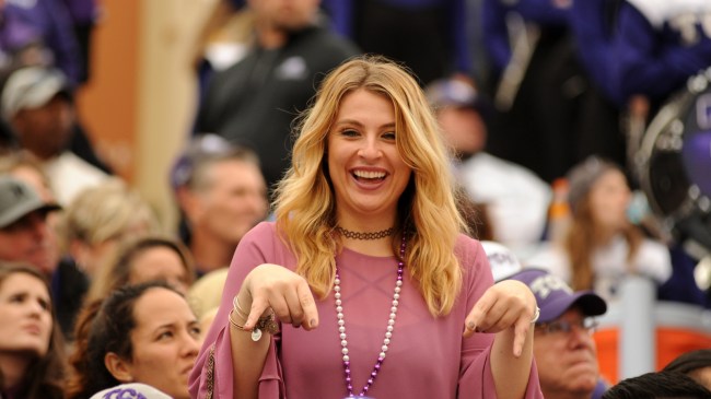 A TCU fan flashes a "Horns Down" sign in the stands.
