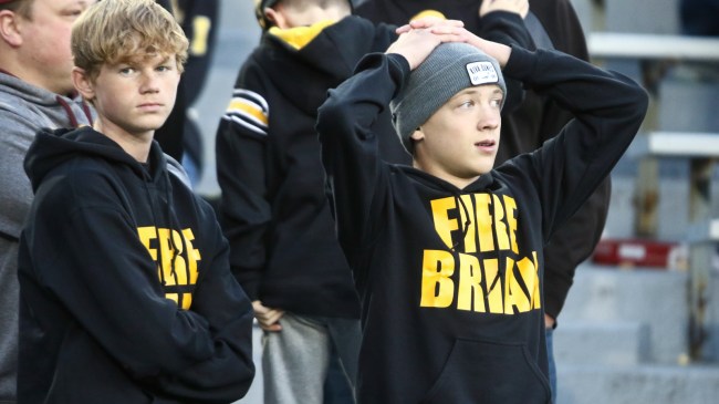 Iowa fans wear "Fire Brian Ferentz" shirts in the stands.