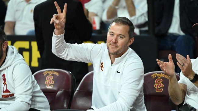 Lincoln Riley acknowledges fans at a USC basketball game.