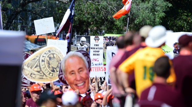 Fans hold signs behind the set of College GameDay.