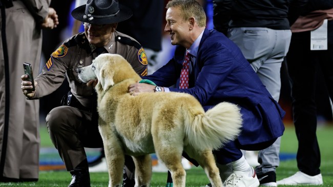 Kirk Herbstreit and his dog, Ben, on the field before a football game.