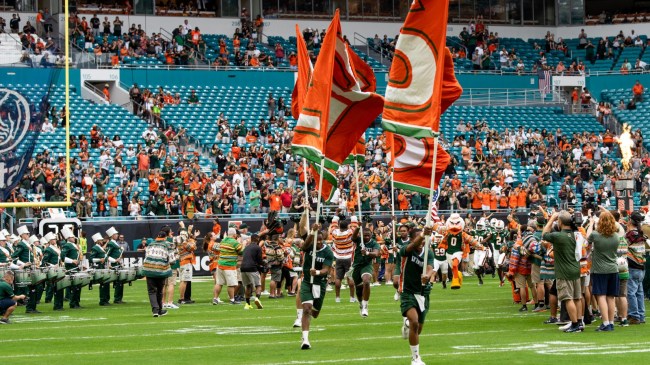 Miami cheerleaders lead the team onto the field.