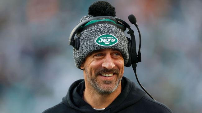 aaron rodgers smiling wearing a jets winter hat