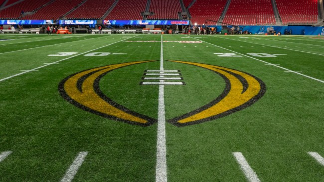 A College Football Playoff logo on the field before a game.