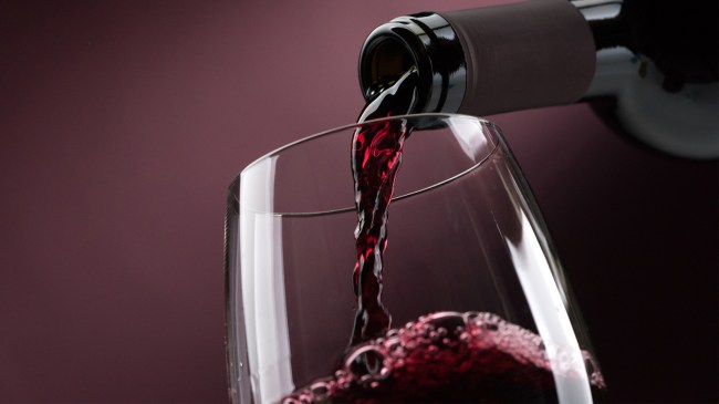 Bottle of red wine being poured into glass