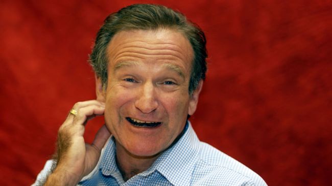 robin williams laughing in a blue dress shirt
