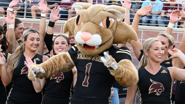 Texas State's mascot and cheerleaders celebrate on the sidelines.