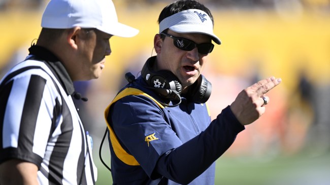 Neal Brown speaks to an official during a West Virginia football game.