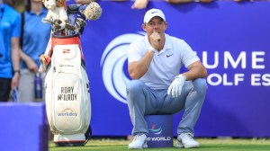 Rory McIlroy sits by golf bag on teee