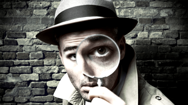 private investigator looking through a magnifying glass