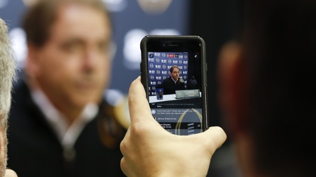 A reporter videos a Nick Saban press conference on Facebook Live.