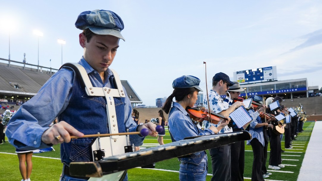 Uniformed Music Students Are Wearing Hats And Playing Musical