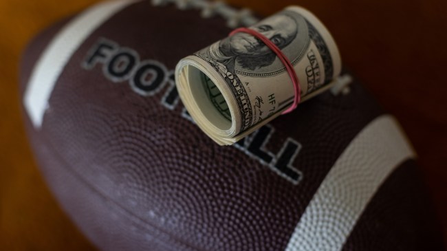 A roll of money rests atop a football.