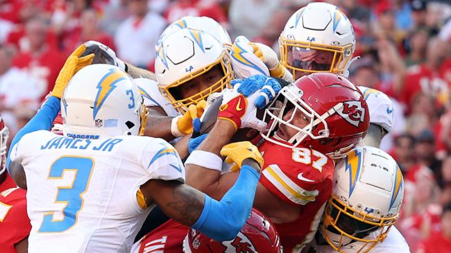 travis kelce being tackled by a group of chargers