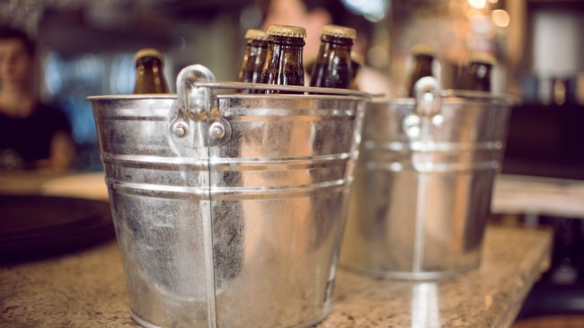 Two buckets of beer on a bar.