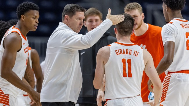 Brad Brownell huddles with the Clemson basketball team on the sidelines.