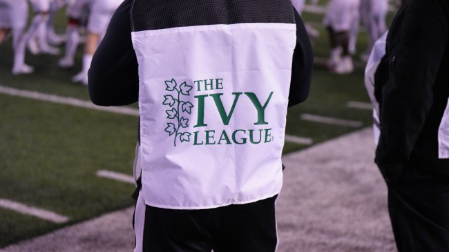 A sideline official sports an Ivy League logo during a football game.