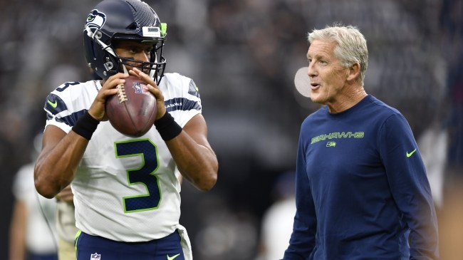 Seattle Seahawks coach Pete Carroll talks to QB Russell Wilson while he warms up before a game.