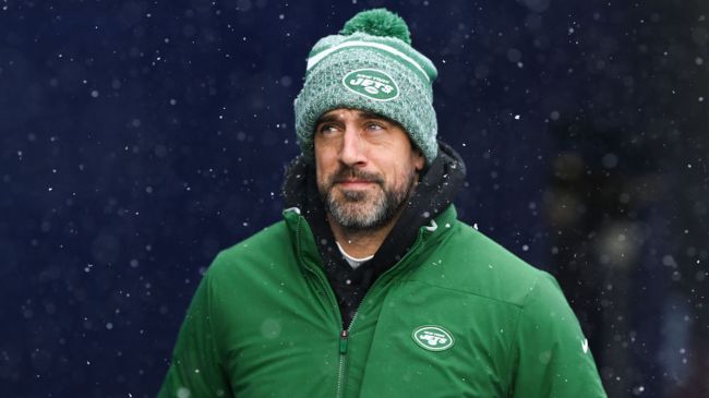 aaron rodgers in a green jets hat and jacket