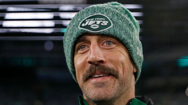 aaron rodgers with a mustache wearing a jets hat