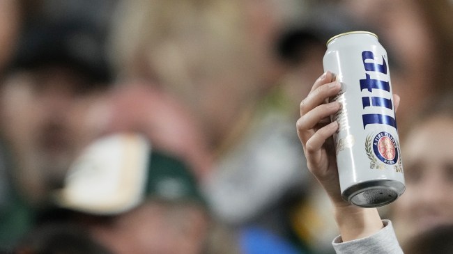 An NFL fan holds a beer in the stands.