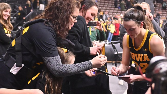 caitlin clark signs autograph for young fan