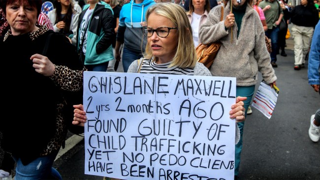 protester carries a placard asking where are the clients in the Ghislaine Maxwell
