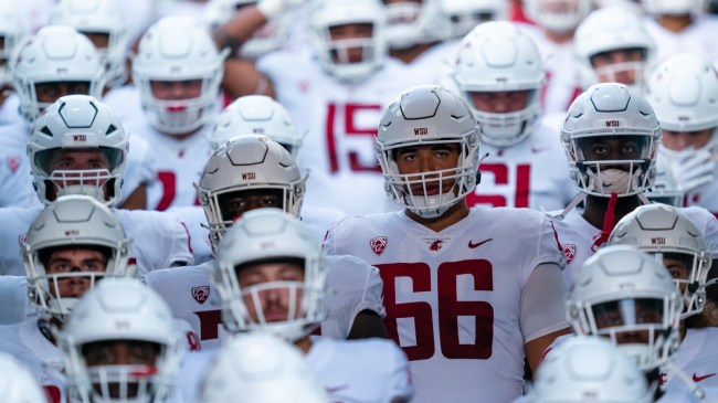 Washington State football players walk out of the tunnel before a game.