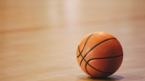 A basketball rests on the court.
