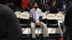 Ben Simmons on the Nets bench in street clothes.