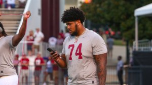 OL Kadyn Proctor on his phone before a game between Alabama and Mississippi State.