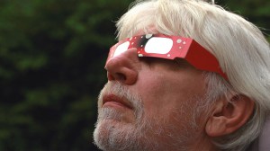 Man wearing solar eclipse glasses