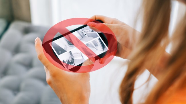 woman monitors security cameras on smartphone indoors
