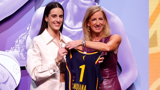 Caitlin Clark holding jersey at WNBA Draft