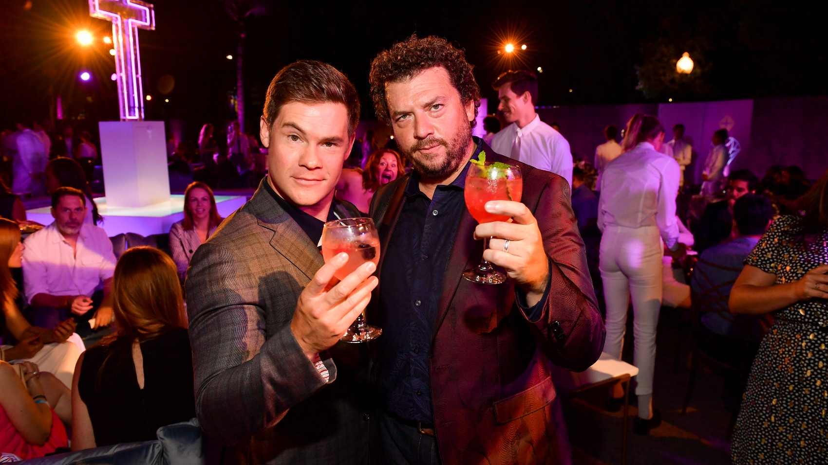 Danny McBride and fellow actor Adam DeVine holding up drinks