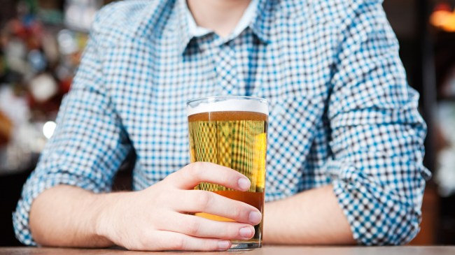 man in a collared shirt holding a beer