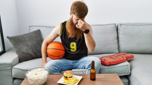 A frustrated fan watches a basketball game.
