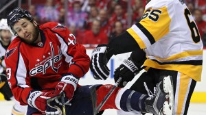 Tom Wilson gets checked during a Penguins-Capitals game
