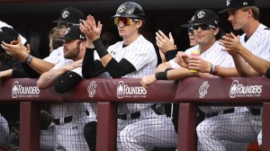 South Carolina baseball players clap in the dugout.