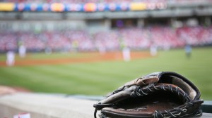 A baseball fan's glove rests on the stadium wall.