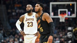 Donovan Mitchell and LeBron James on the floor during a game between the Lakers and Cavs.