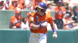 Clemson baseball's Alden Mathes celebrates a hit while running down the baseline.